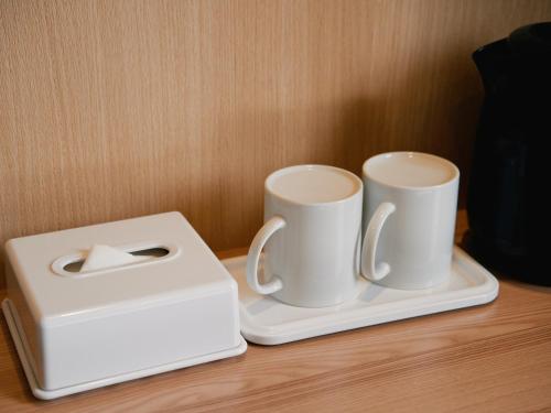 two coffee cups on a tray next to a toaster at Hotel -ASIATO- in Osaka