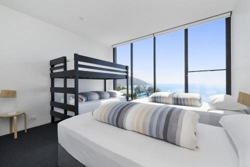 two beds in a bedroom with a large window at Cape Wye in Wye River