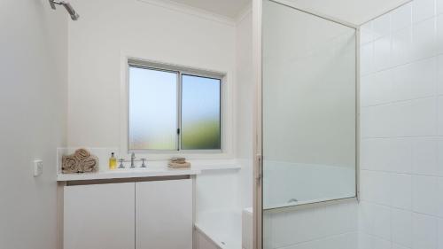 a bathroom with a shower and a sink and a window at Farm House in Johanna
