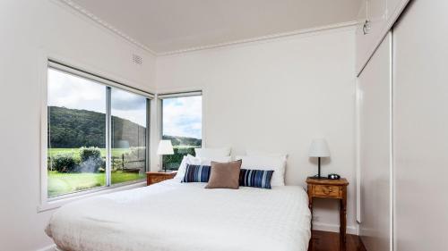 a bedroom with a white bed and a large window at Farm House in Johanna