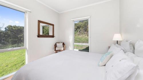 a white bedroom with a large bed and a window at Joanna in Johanna