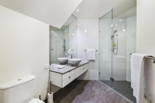 a white bathroom with two sinks and a shower at Manta Ray One in Apollo Bay