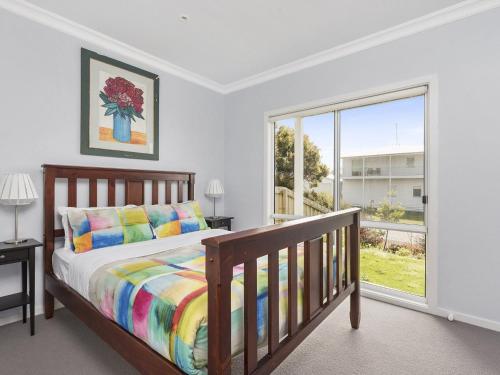 a bedroom with a bed and a large window at Art House in Apollo Bay