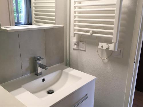 une salle de bain blanche avec un lavabo et un miroir dans l'établissement Studio rénové près du centre et de la plage avec parking et mezzanine - FR-1-4-594, à Saint-Jean-de-Luz