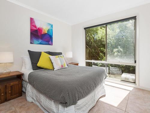 ein Schlafzimmer mit einem Bett und einem großen Fenster in der Unterkunft Coral Reef in Marengo