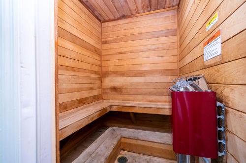 una sauna de madera con un cubo de basura roja. en Beautiful cozy Retreat near Disney - spacious condo, en Kissimmee