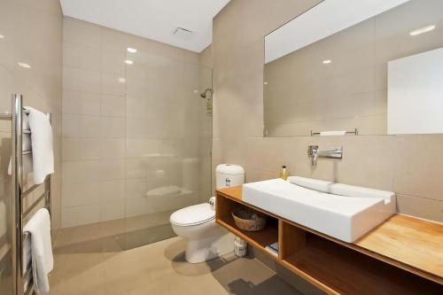 a bathroom with a white sink and a toilet at Coastal Break in Wye River