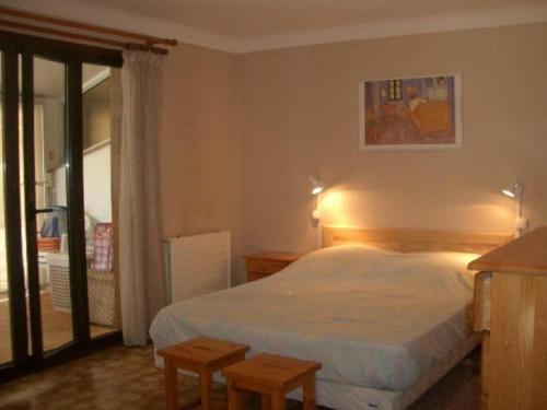 a bedroom with a bed and two stools in it at Charmant F2 avec Garage, Terrasse et Véranda, à 500m du Centre et 600m des Cures à Amélie-les-Bains - FR-1-703-131 in Amélie-les-Bains-Palalda