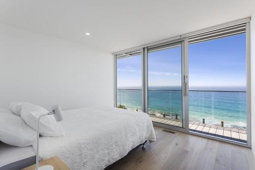 a white bedroom with a view of the ocean at Southpoint -Brand new home, oceanfront views in Wye River