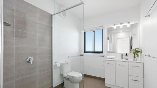 a white bathroom with a toilet and a shower at The Blue House in Wye River
