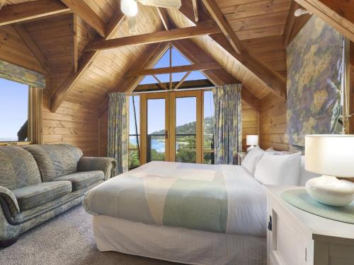 a bedroom in a log cabin with a bed and a couch at A Wye s Choice in Wye River