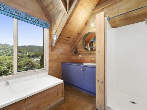baño con ventana grande, bañera y lavamanos en A Wye s Choice, en Wye River