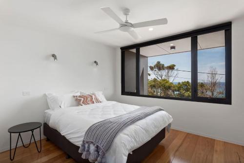 a bedroom with a bed and a large window at The Cube in Wye River