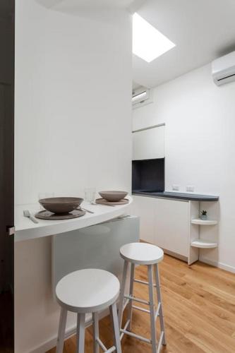 a kitchen with two stools and a counter with a stove at city centre Navigli- studio in Milan