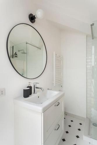 a white bathroom with a sink and a mirror at city centre Navigli- studio in Milan