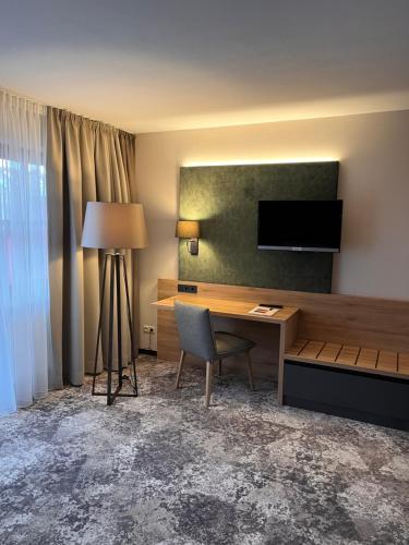 a hotel room with a desk and a television at Appartment-Hotel-Hölzl in Grünwald