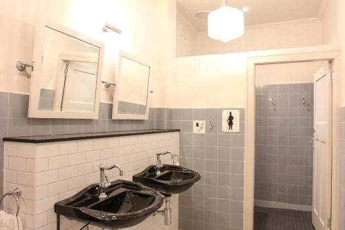 a bathroom with two sinks and a mirror at Alpine Hotel, Eat Drink Sleep in Warburton