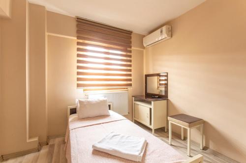 Habitación pequeña con cama y espejo. en Beyoglu Huzur Hotel, en Estambul