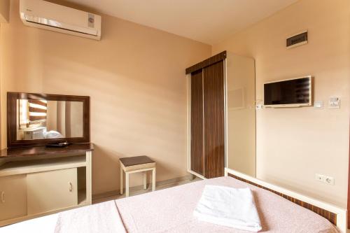イスタンブールにあるBeyoglu Huzur Hotelのベッドと鏡が備わるホテルルーム