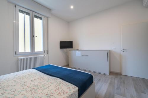 - une chambre blanche avec un lit et une télévision dans l'établissement Bologna Accommodation Fiera 3- Self Checkin - H24, à Bologne