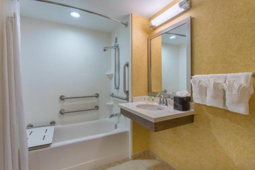 a bathroom with a sink and a tub and a shower at Holiday Inn Baltimore BWI Airport by IHG in Linthicum Heights