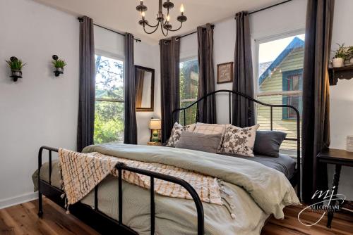a bedroom with a black bed with windows at The Peabody House in Eureka Springs