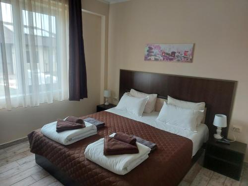 a bedroom with a large bed with two towels on it at Вилен комплекс Дарибел in Sapareva Banya