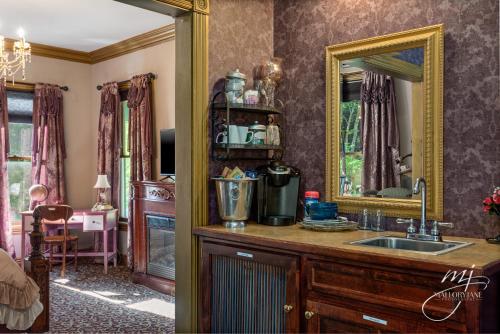 a bathroom with a sink and a mirror at The Peabody House in Eureka Springs