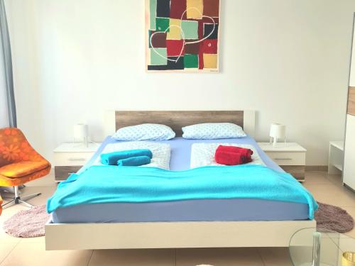 sypialnia z łóżkiem z niebieską pościelą i czerwonymi poduszkami w obiekcie Apartment am Landeckberg w mieście Klingenmünster