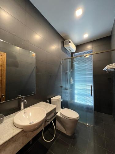 La salle de bains est pourvue de toilettes, d'un lavabo et d'une douche. dans l'établissement Nancy Grand Strip Villa Imperial 1, à Vung Tau