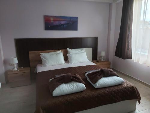 een slaapkamer met een bed met 2 kussens erop bij Вилен комплекс Дарибел in Sapareva Banya
