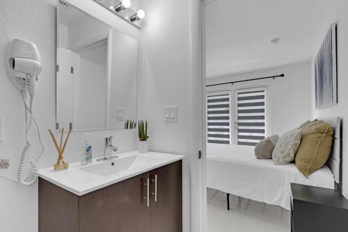 La salle de bains est pourvue d'un lavabo et d'un lit dans la chambre. dans l'établissement Private & Modern Home with 4 Bedrooms, à Homestead