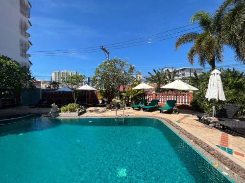 a swimming pool with blue water in front of a building at Pattara Mansion พัทยา in North Pattaya