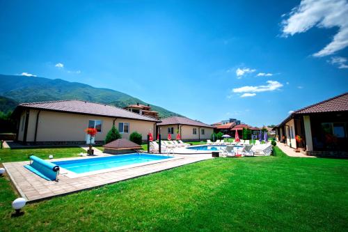 a backyard with two swimming pools and green grass at Вилен комплекс Дарибел in Sapareva Banya