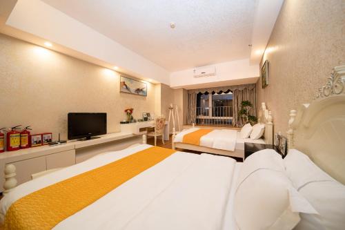 a bedroom with two beds and a flat screen tv at Orange International Hotel Guangzhou Zhujiang New Town US Consulate General Guangzhou Branch - Free Shuttle Bus to Canton Fair Complex During Canton Fair Period in Guangzhou