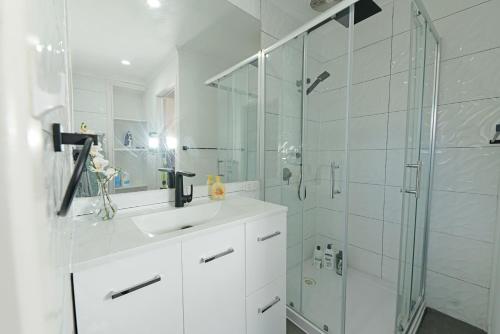 y baño blanco con lavabo y ducha. en Pet-friendly Bayside 4BR Rental House near Mentone en Parkdale