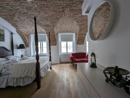 um quarto com uma cama e uma parede de tijolos em Fantabulous Upper-Town Condo em Zagreb