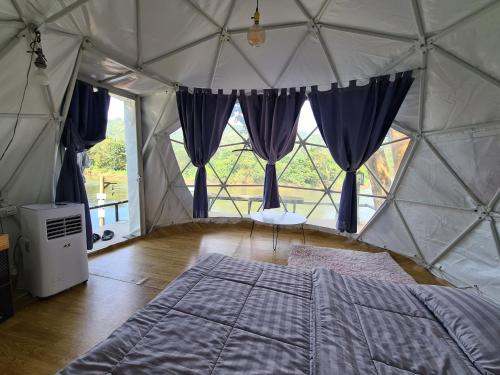 a bedroom with a bed in a canvas tent at Phuphavaree by Tahug Sai Yok in Ban Ai Hit
