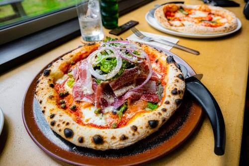 a pizza on a brown plate on a table at MolinHotels501 アクティビティを満喫できる札幌定山渓温泉付き別荘 - W-Bed4&S-6 10persons in Sapporo