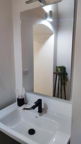 a bathroom sink with a mirror and a faucet at Amalò Guest House in Bari