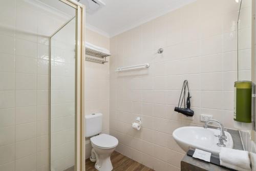 a bathroom with a toilet and a sink at Caboolture Central Motor Inn, Sure Stay Collection by BW in Caboolture