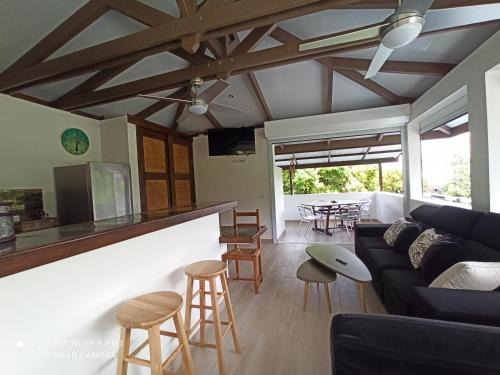 a living room with a couch and a bar at La Maison Du Voyage in Tevaitoa