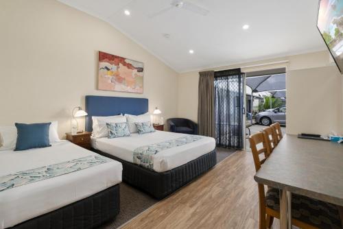 a hotel room with two beds and a table at Caboolture Central Motor Inn, Sure Stay Collection by BW in Caboolture