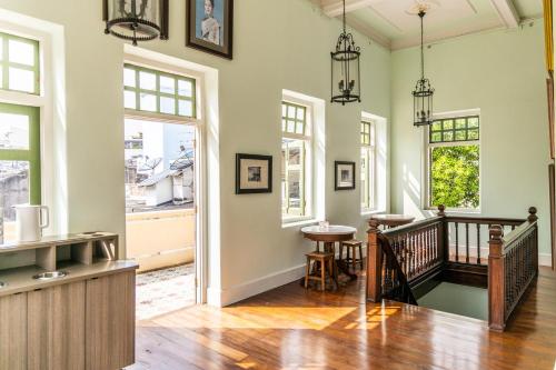 a living room with a staircase and windows at Baan 2459 Heritage House in Bangkok
