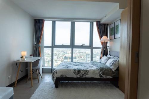 a bedroom with a bed and a large window at A2J Luxury 2BR BGC Uptown Suite Near Uptown Mall in Manila