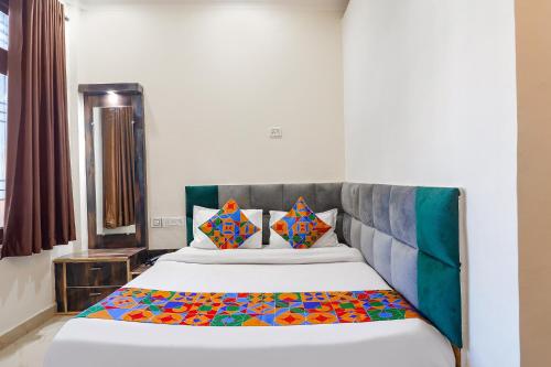 a bedroom with a large bed with colorful pillows at FabHotel Royal Vilas in Gwalior
