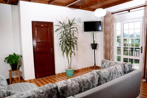 a living room with a couch and a tv at The Fern Inn in Nuwara Eliya