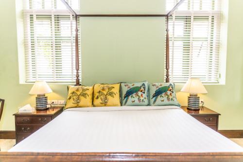 a bedroom with a large white bed with two lamps at Baan 2459 Heritage House in Bangkok
