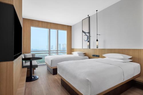 a hotel room with two beds and a television at Fairfield by Marriott Changzhou Jintan in Changzhou