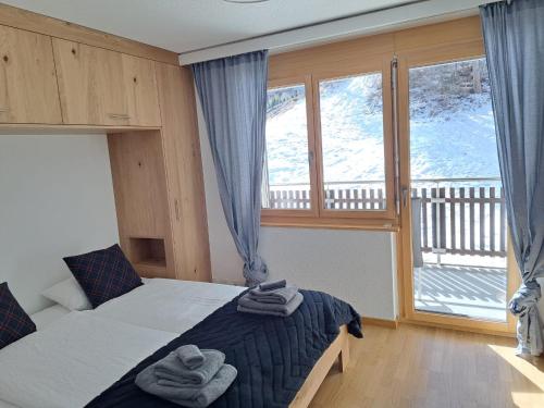 um quarto com uma cama e uma grande janela em Haus Vitalis em Zermatt